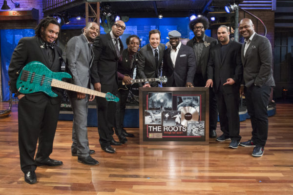 LATE NIGHT WITH JIMMY FALLON -- Episode 819 -- Pictured: (center) Jimmy Fallon presents the Roots (l-r) Mark Kelley, Damon "Tuba Gooding Jr." Bryson, F. Knuckles, Captain Kirk Douglas, Black Thought, Questlove, Kamal Gray, James Poyser with a plaque commemorating their first RIAA-certified platinum album for their 1999 release, "Things Fall Apart" on April 22, 2013 -- (Photo by: Lloyd Bishop/NBC/NBCU Photo Bank via Getty Images)