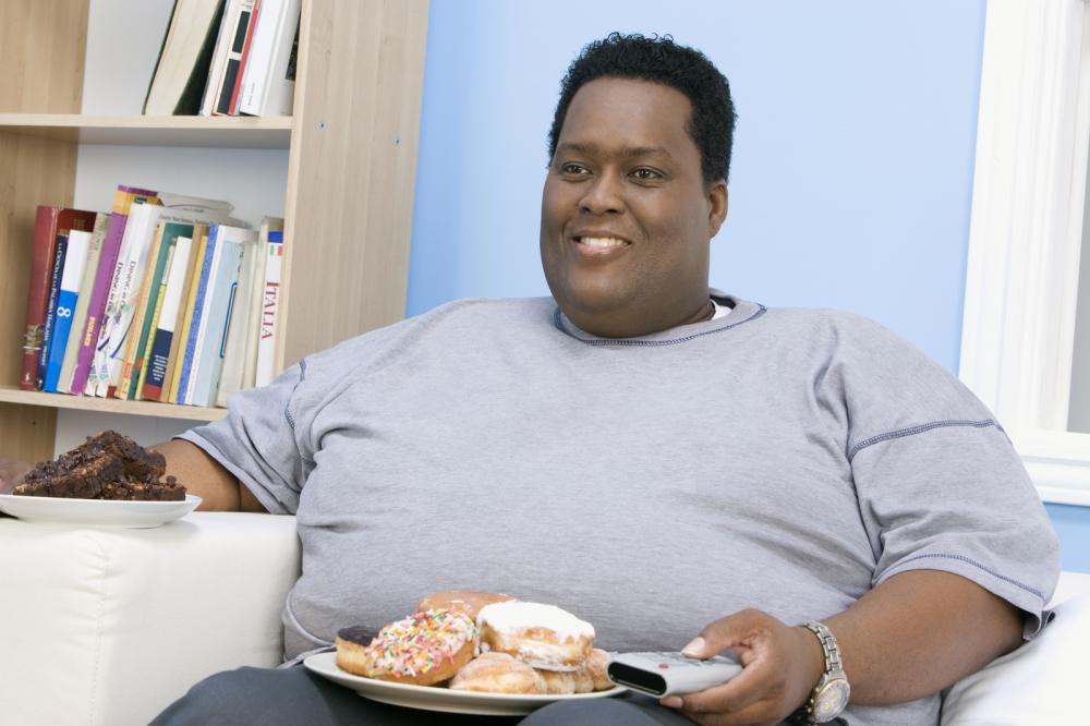 an-african-american-obese-man-watching-television-with-plate-of-donut