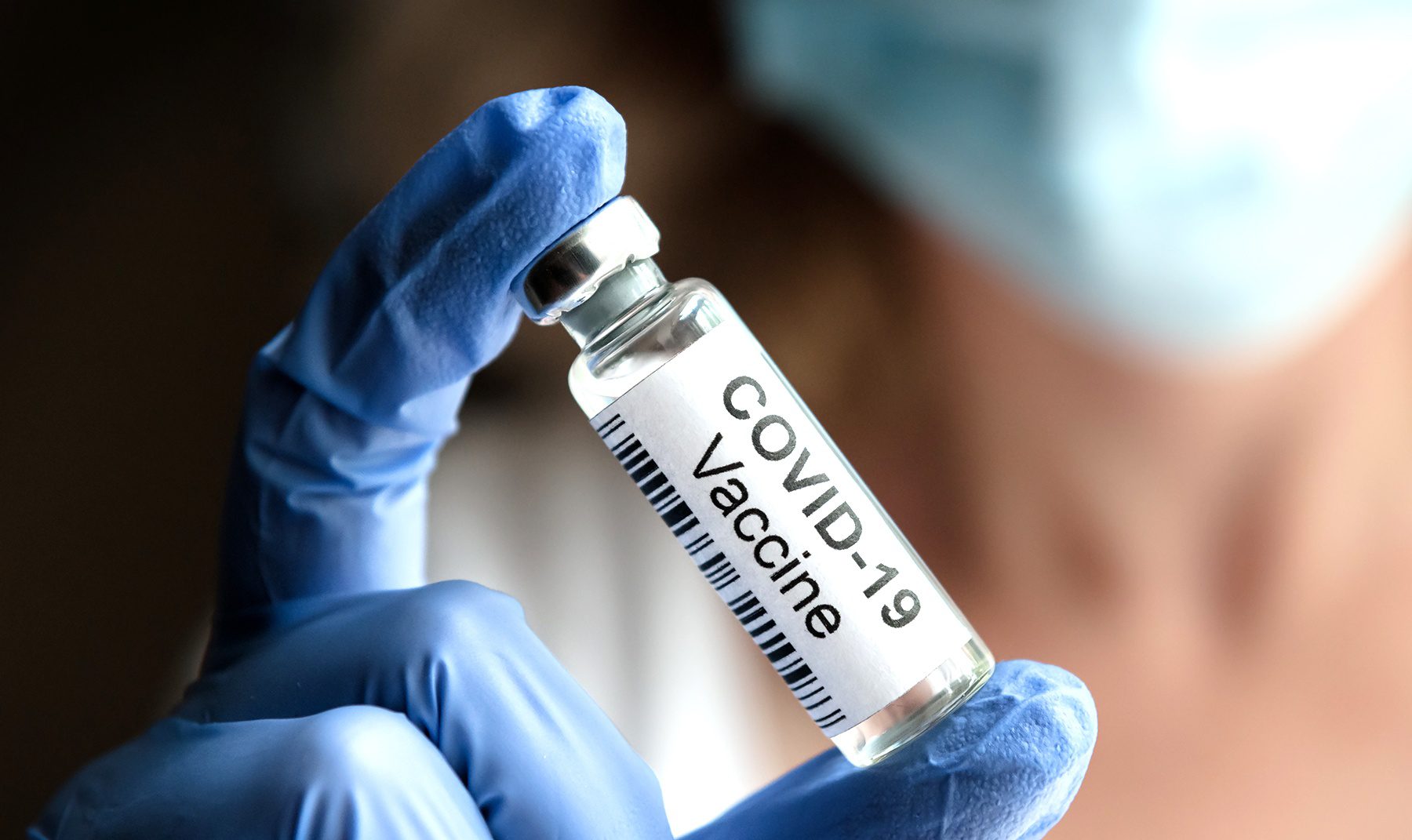 COVID-19 vaccine concept, female doctor holds coronavirus medica