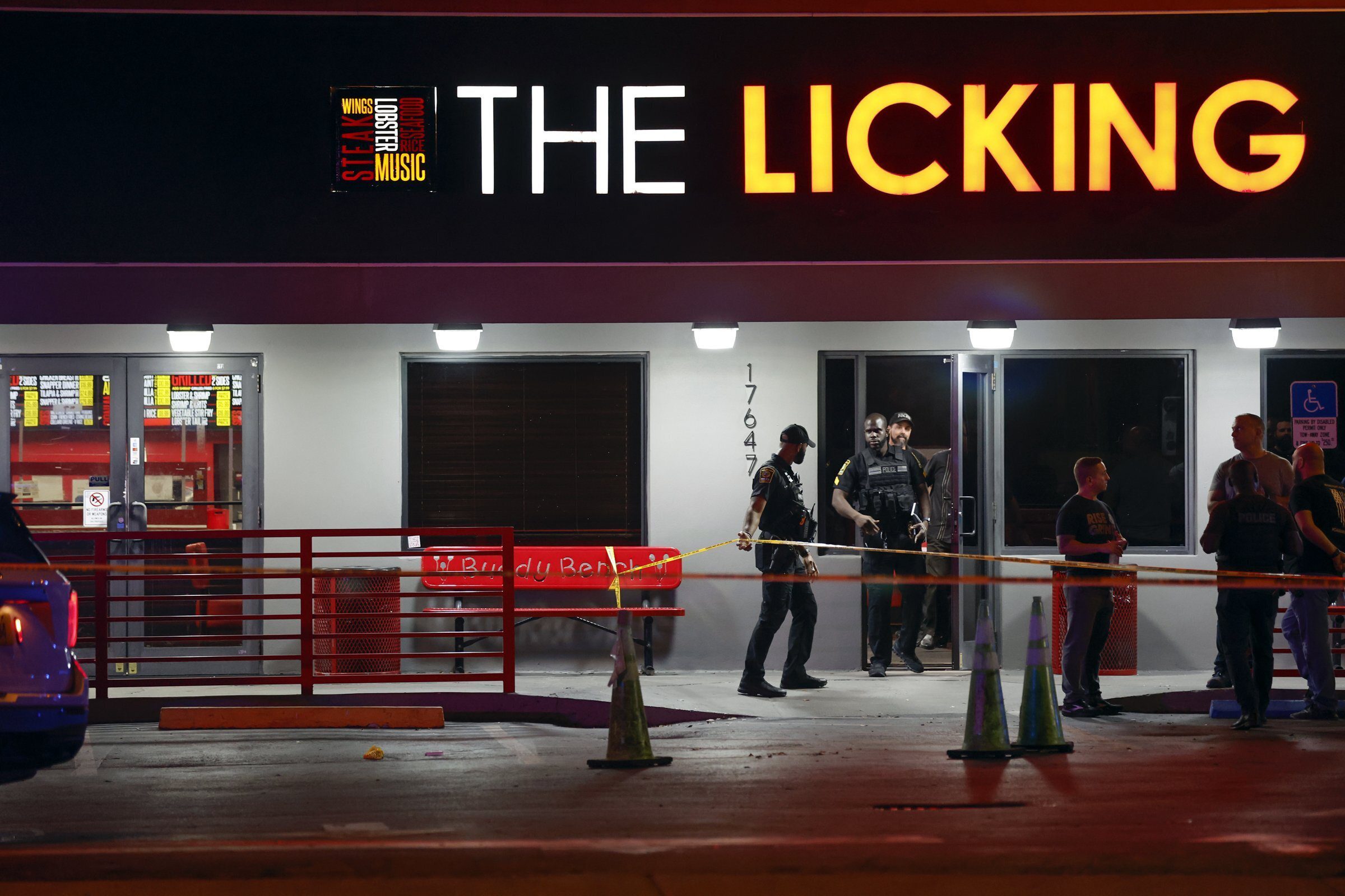 Miami Gardens police officers respond to The Licking Restaurant after multiple people were reportedly shot Thursday night Jan. 5, 2023 in Miami Gardens, Fla. Investigators were looking into reports that a video was being shot at the restaurant, Miami Gardens Police Chief Delma Noel-Pratt said. (Al Diaz/Miami Herald via AP)